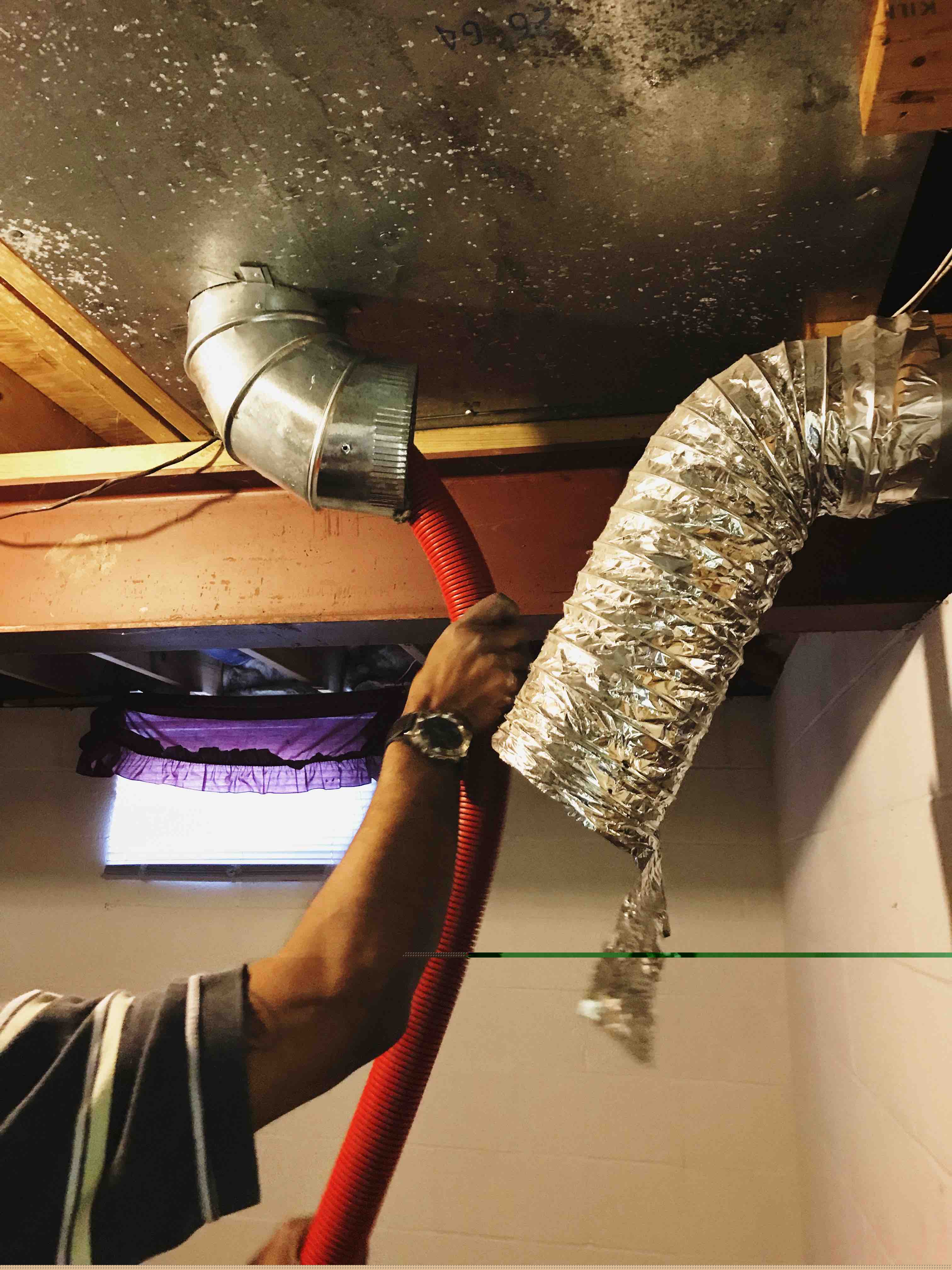 A man holding a hose cleaning an air duct line for Sanitize 4 Serenity 